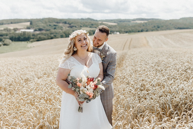 Brautpaar Plussize im Bohostyle. Hochzeitskleid in großer Groesse im Boholook. Anzug hell kariert mit fliege. Brautmode große Größe in Bad Kreuznach, Mainz, Koblenz, Wiesbaden, Kaiserslautern.